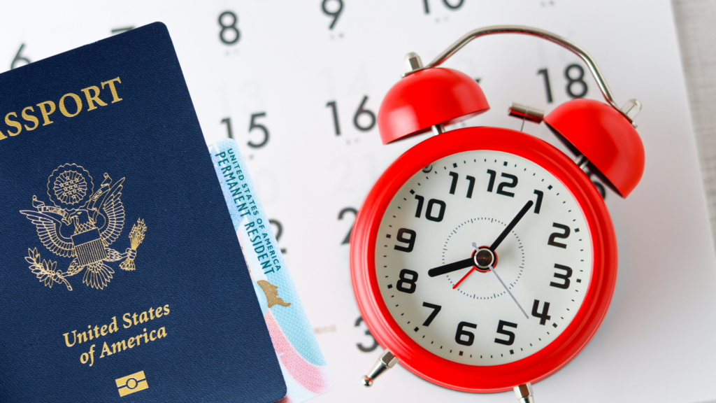 U.S. passport and green card beside a red alarm clock and calendar. Signifying Eb2 Processing Time