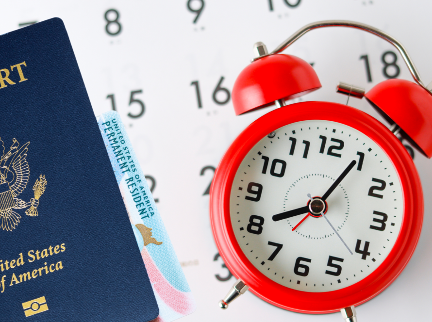U.S. passport and green card beside a red alarm clock and calendar. Signifying Eb2 Processing Time